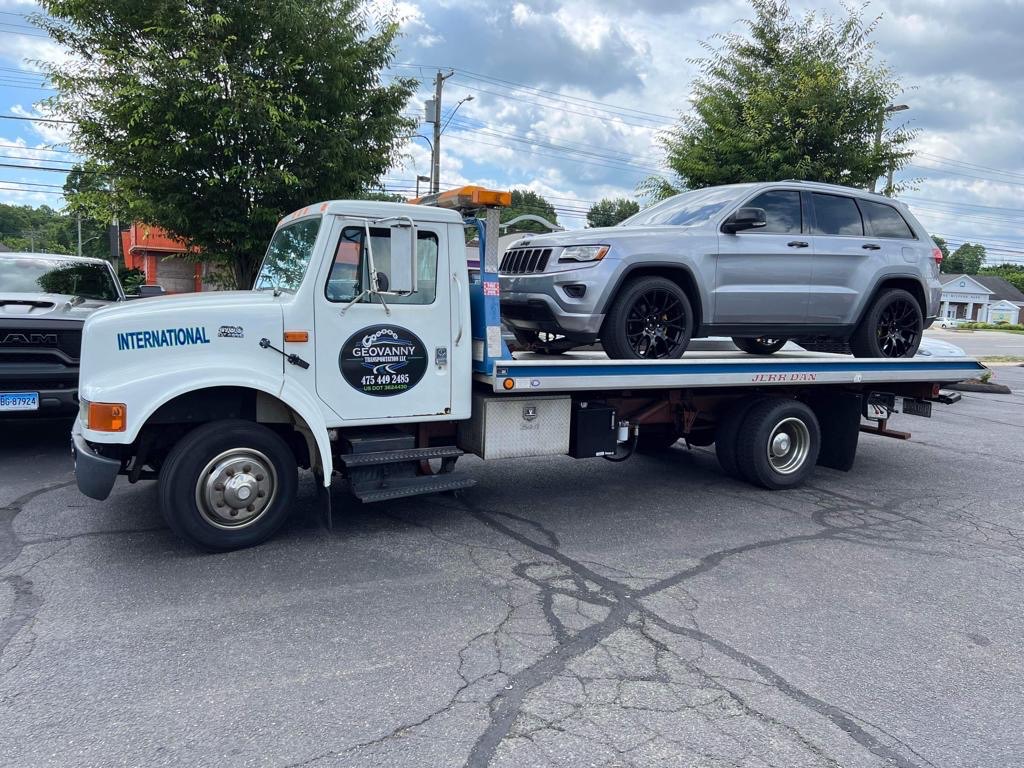Flatbed tow truck transporting a Jeep in Connecticut